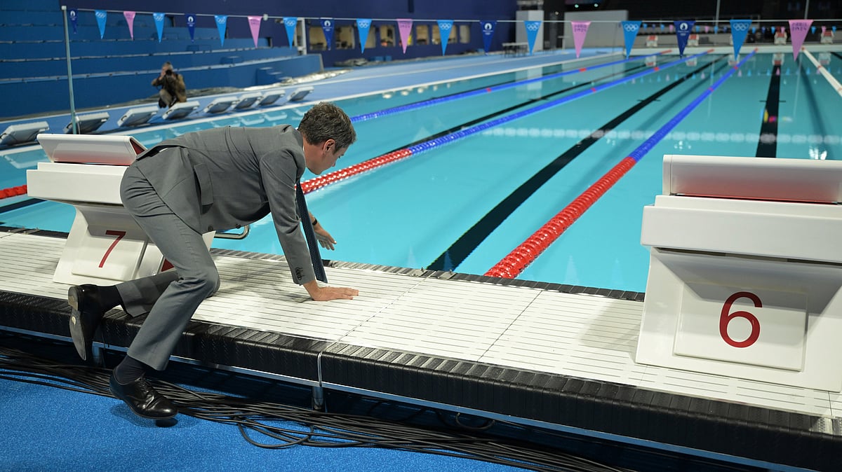 French Prime Minister Gabriel Attal touches the water at the swimming pool for Olympic competitions, at the Paris La Defense Arena in Nanterre, outside Paris, Monday July 5, 2024. The Paris La Defense Arena will host the swimming and some water polo events during the Paris 2024 Olympic Games. -  (Bertrand Guay/ Pool via AP)


